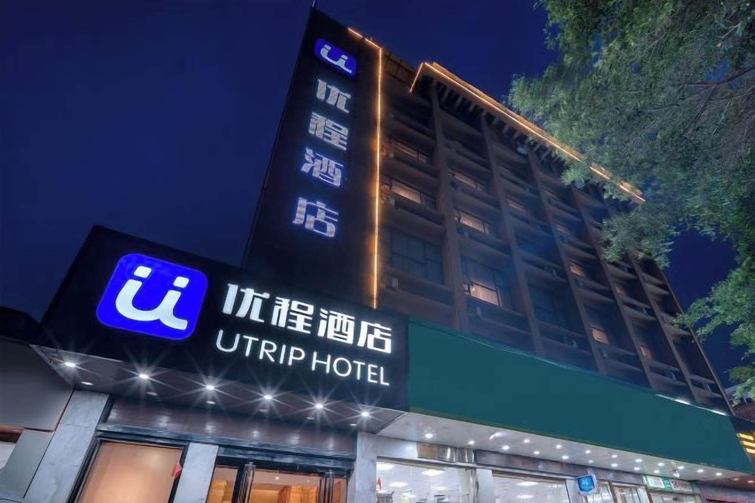 A hotel with a prominent sign for UTRIP HOTEL and a large illuminated logo.