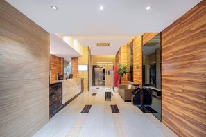 A hotel lobby with a reception desk, seating area, and a TV screen. - Nanning Unitour Hotel (Nanning)
