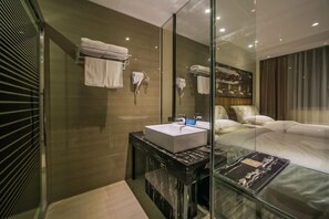 A modern bathroom with a glass-enclosed shower, a marble vanity, and a large mirror. - Nanning Unitour Hotel (Nanning)