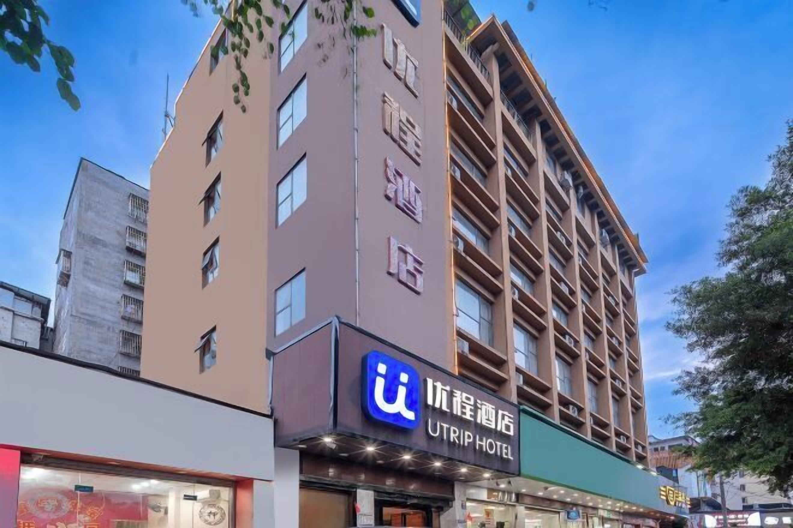 A hotel with a sign reading "UTRIP HOTEL" and a large building with multiple floors and balconies.
