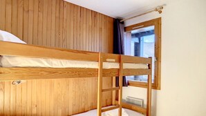 Ein Schlafraum mit Etagenbetten, Holzwänden und einem Fenster.