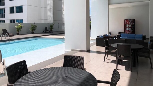 Zwembadgedeelte met een lounge en zitplaatsen, een trap en een moderne gevel.
