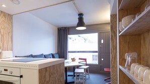 Una cocina moderna con horno integrado y comedor con mesa y sillas.
