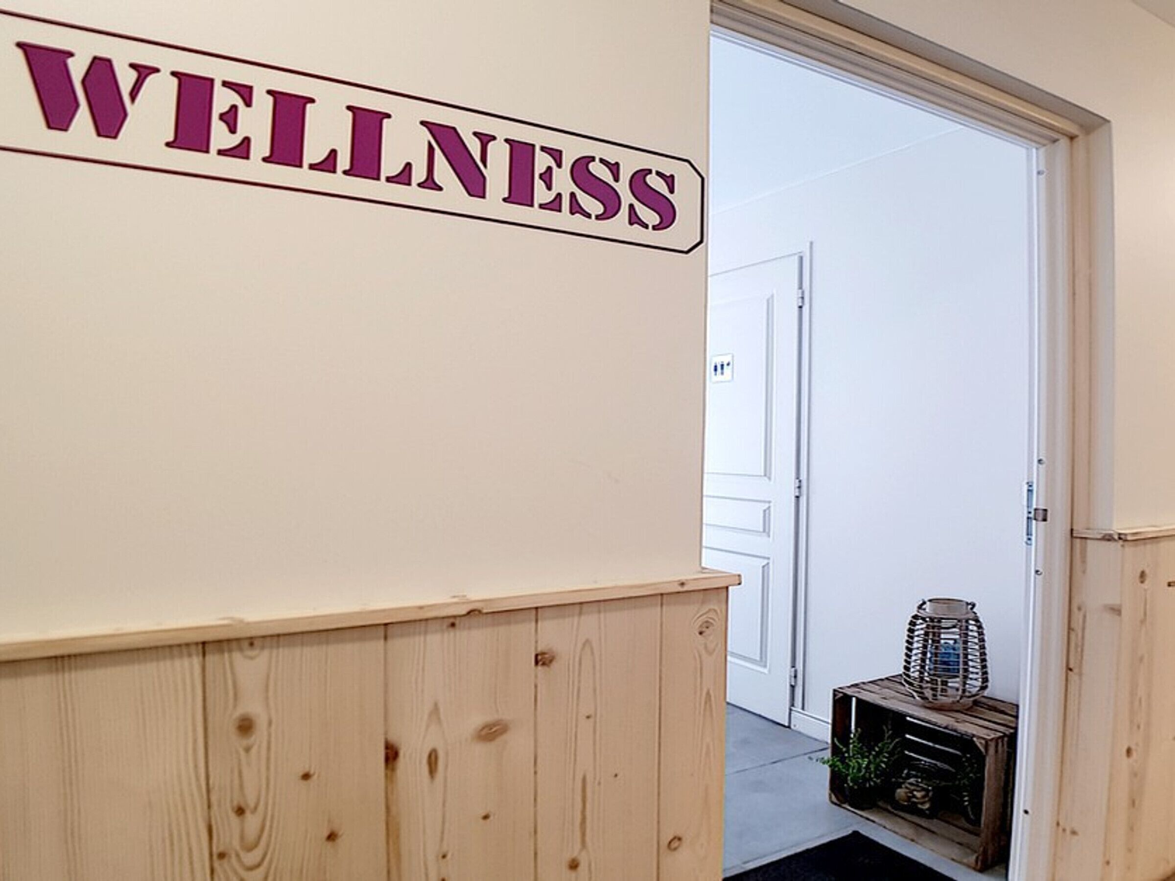 Un corridoio con un cartello appeso al muro che indica 'WELLNESS'.