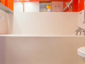 Une salle de bain moderne avec une baignoire blanche, une douche et des toilettes.