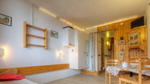 Une pièce comprenant un lit en bois, une table à manger avec des chaises et un buffet en bois.