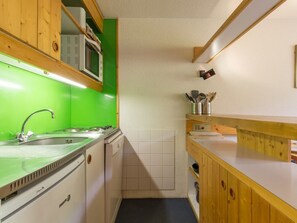 A compact kitchen with a green backsplash, wooden cabinets, a stainless steel sink, and a microwave. - Ski-in/ski-out duplex with balcony, 6 pers. (Les Arcs 1800)