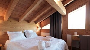 Ein Holzhütten-Zimmer mit einem Bett, einem Schreibtisch und einem Fenster.