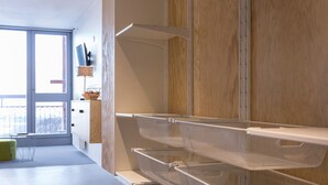 Una cocina moderna con armarios blancos, una pared de madera y un ventanal con vistas a la ciudad.