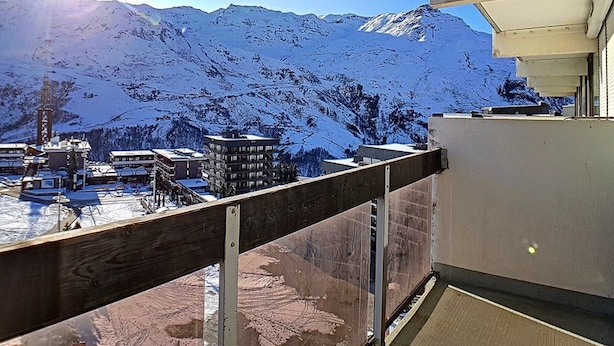 Paisaje montañoso cubierto de nieve con un edificio en primer plano.