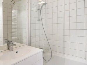 Ein modernes Badezimmer mit Waschbecken, Spiegel und Dusche.