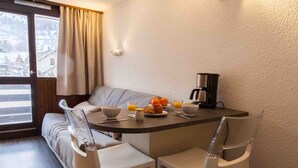 Ein gemütliches Frühstücksbuffet mit Tisch, Stühlen und einer Kaffeemaschine.