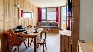 Un intérieur en bois comprenant une table à manger, des chaises, un canapé et un téléviseur.