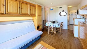 Ein gemütlicher Wohnbereich mit einer Couch, Esstisch, Stühlen und Holzschränken.