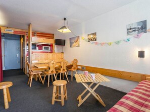 Um quarto acolhedor com móveis de madeira, um pequeno espaço de cozinha e um painel decorado com a palavra 'SUPPER'.
