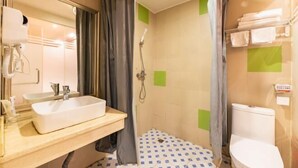 Un baño con lavamanos, espejo, cortina de ducha e inodoro.