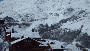 A snow-covered mountain with wooden cabins in the foreground.