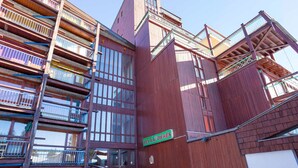 Un immeuble en bois à plusieurs étages, doté de balcons et de grandes fenêtres.