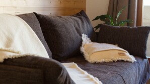 Ein dunkelbraunes Sofa mit einer weißen Decke und einem beigen Kissen mit Etikett.