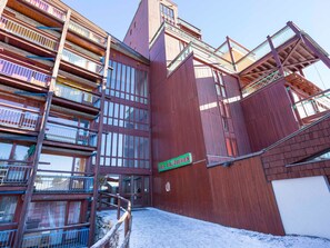 Un immeuble en bois à plusieurs étages, doté de balcons et d’une enseigne indiquant « LES LAUZIÈRES ».