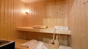 A wooden sauna with benches, a towel rack, and a bucket. - Spacious chalet with sauna, slope access, Wi-Fi and parking (Saint-Martin-de-Belleville)