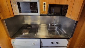 Une cuisine compacte équipée d’une cuisinière, d’un évier et de deux fours à micro-ondes.
