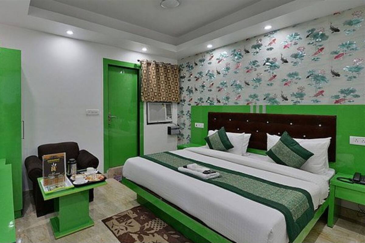 Una habitación de hotel con una cama grande, un escritorio, una silla y un armario.