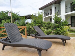 Two wicker lounge chairs with a wooden table in an outdoor setting. - The Boathouse at Calatagan (Calatagan)