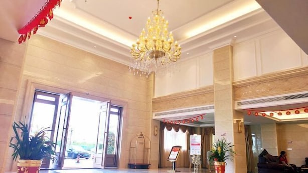 A spacious lobby with a chandelier, potted plants, and a reception area. - Xin Zhenhao Business Hotel (Shantou)