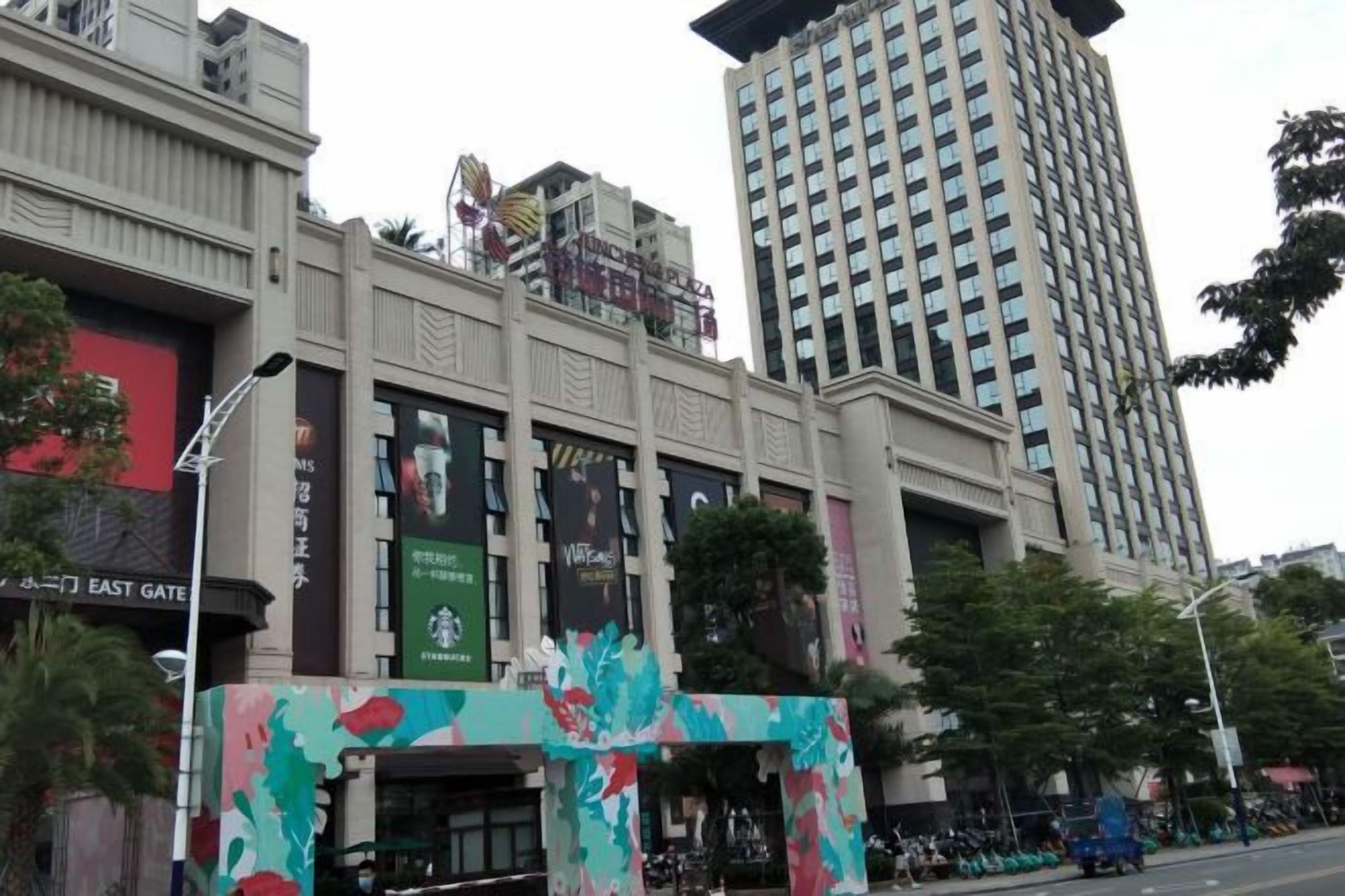 Un edificio de varios pisos con una entrada destacada, ventanas amplias y banderines.