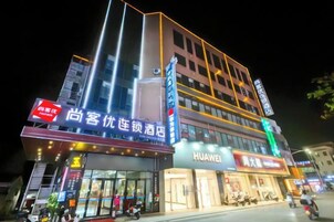 Un hotel de varios pisos con señalización de un hotel y un restaurante.