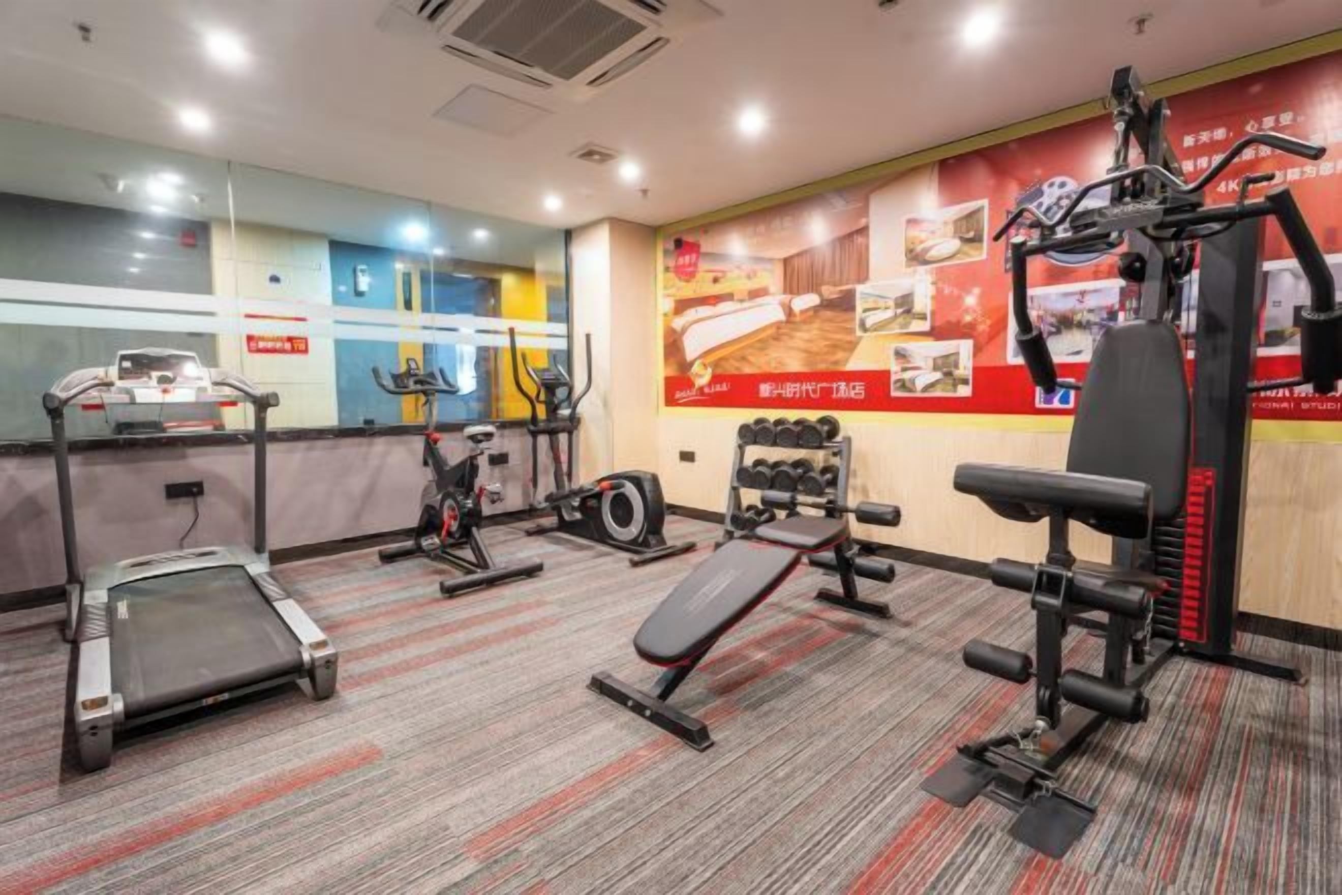 A gym with treadmills, elliptical machines, and weightlifting equipment.