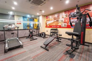 Ginásio com esteiras, elípticos e equipamentos de musculação.