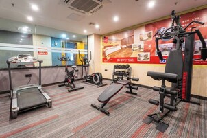 Un gimnasio con cintas de correr, elípticas y equipamiento de levantamiento de pesas.