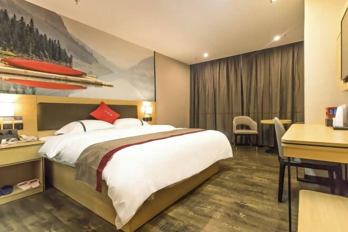 Une chambre d’hôtel comprenant un lit, une table de chevet, une chaise et un bureau.