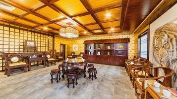 A traditional interior with wooden furniture, a central round table, and a tiger mural.