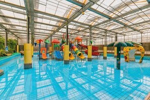 Une piscine intérieure dotée de toboggans et d’aires de jeux.