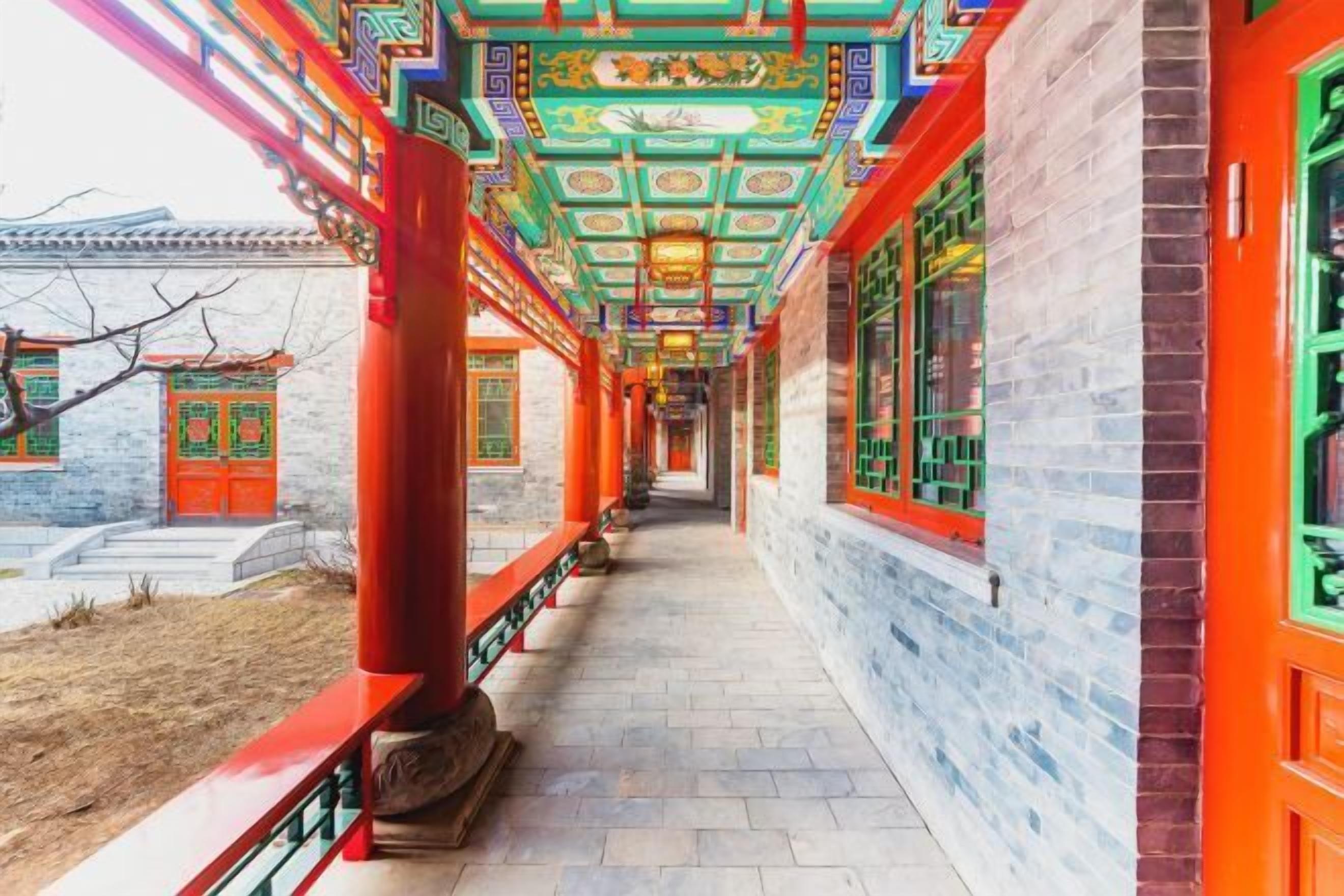 A corridor with traditional Chinese architecture, featuring red columns and ornate ceiling decorations.