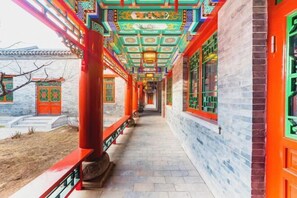 A corridor with traditional Chinese architecture, featuring red columns and ornate ceiling decorations. - Succeed Hotel (Tangshan)