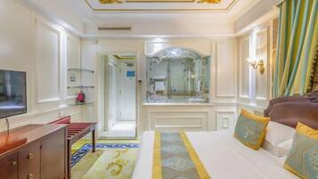 A hotel room with a bed, a TV, a dresser, a mirror, and a bathroom door.