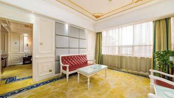 A room with a red sofa, a glass coffee table, and a yellow patterned carpet.