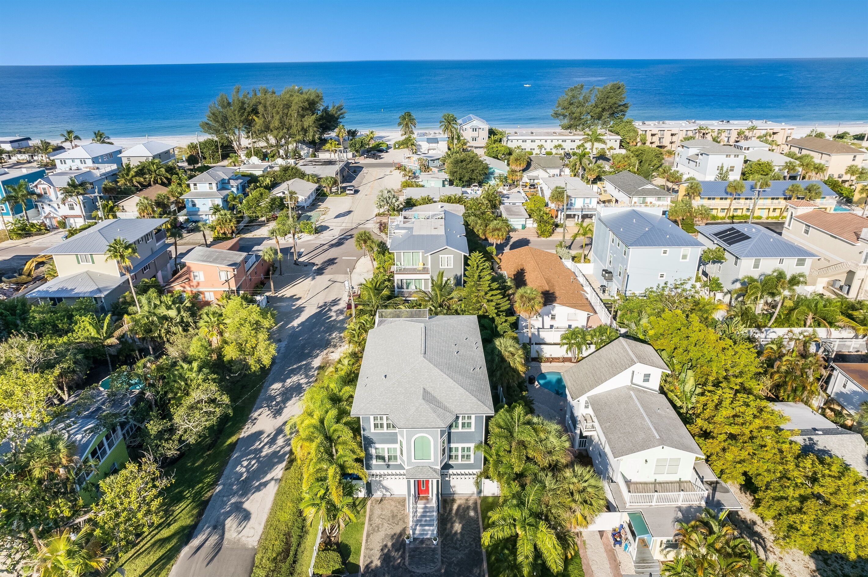 Vista aérea de una zona residencial costera con casas, carreteras y una playa.