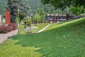 A grassy area with a pathway leading to a building with a modern architectural design.