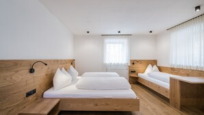 Ein modernes Schlafzimmer mit einem hölzernen Bett, Nachttischen und einer eingebauten Sitzbank.
