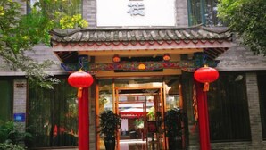 A traditional Chinese building entrance with a red lantern and tiled roof. - Qincaige Hostel (Chongqing)
