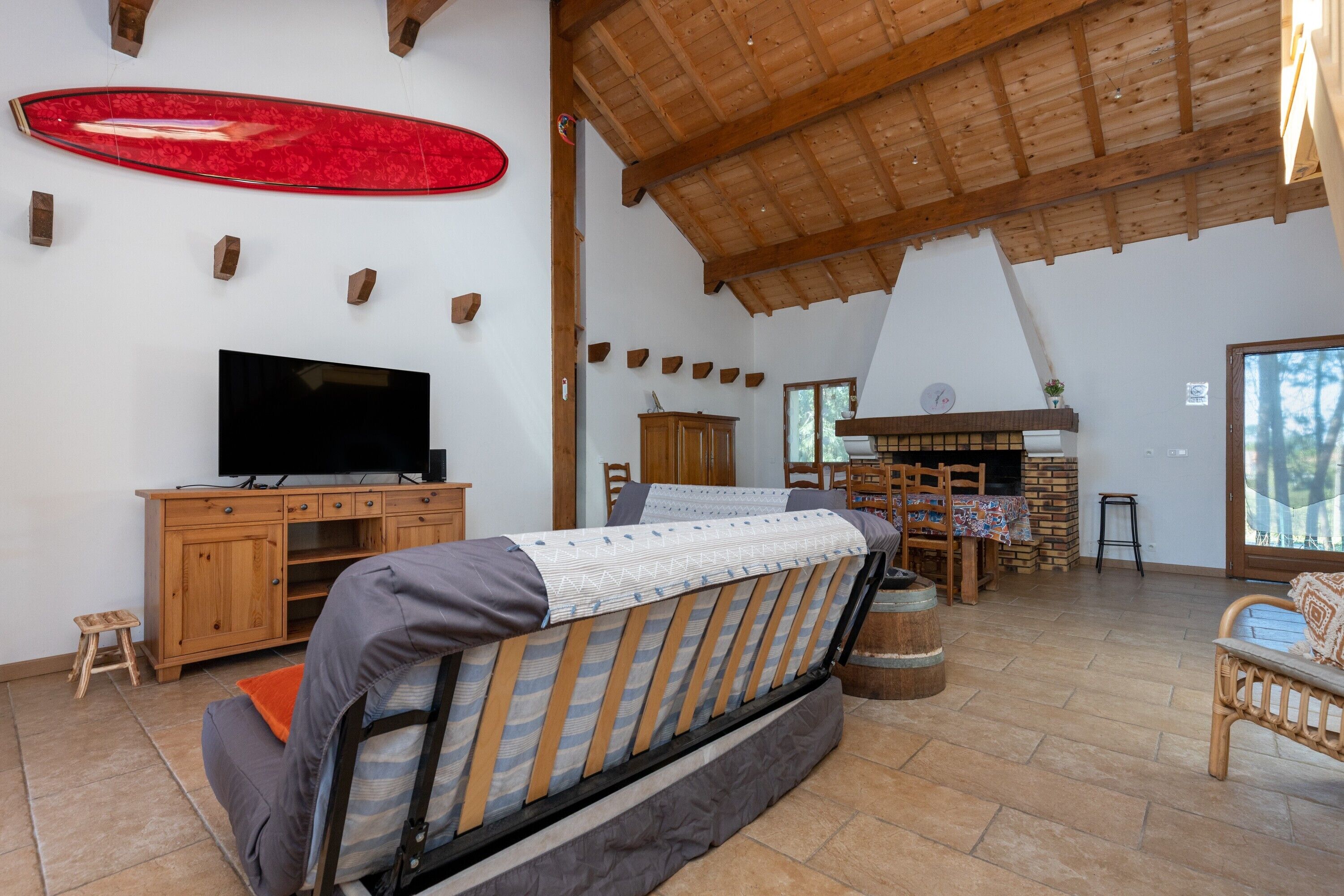 Un salon chaleureux avec un canapé, des meubles en bois, une télévision et une cheminée.