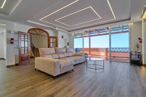 Una sala de estar moderna con un sofá modular, una mesa de centro redonda y un ventanal con vistas al exterior.