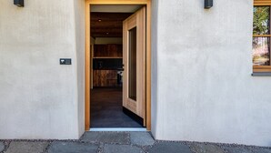 A doorway leading to a kitchen with wooden cabinets and a stone-tiled floor. - Holiday Apartment Egger an der Lahn - Nonno with Mountain View, Terrace and Wi-Fi (San Genesio)