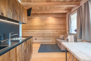 Une cuisine moderne avec des murs en bois, un canapé et une table à manger.