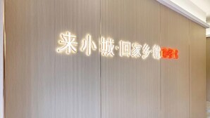 A wooden wall with illuminated text, likely indicating a hotel or accommodation name. - Shankee Chain Hotel (Zhuhai Jing'an Bridge) (Zhuhai)